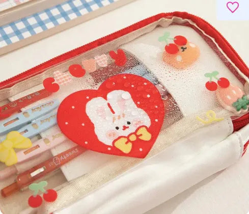 Transparent heart-shaped pencil case with Korean style design in pink rabbit theme showing pens inside