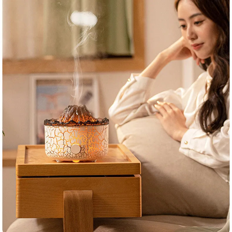 Column-shaped volcano humidifier diffuser emitting coloured mist and LED light flame effect.