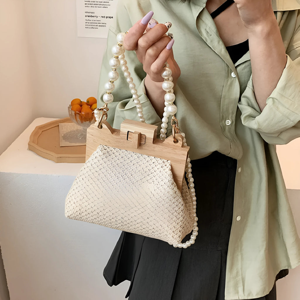 Women's woven straw shoulder bag with pearl chain detail showing horizontal square shape and internal compartments