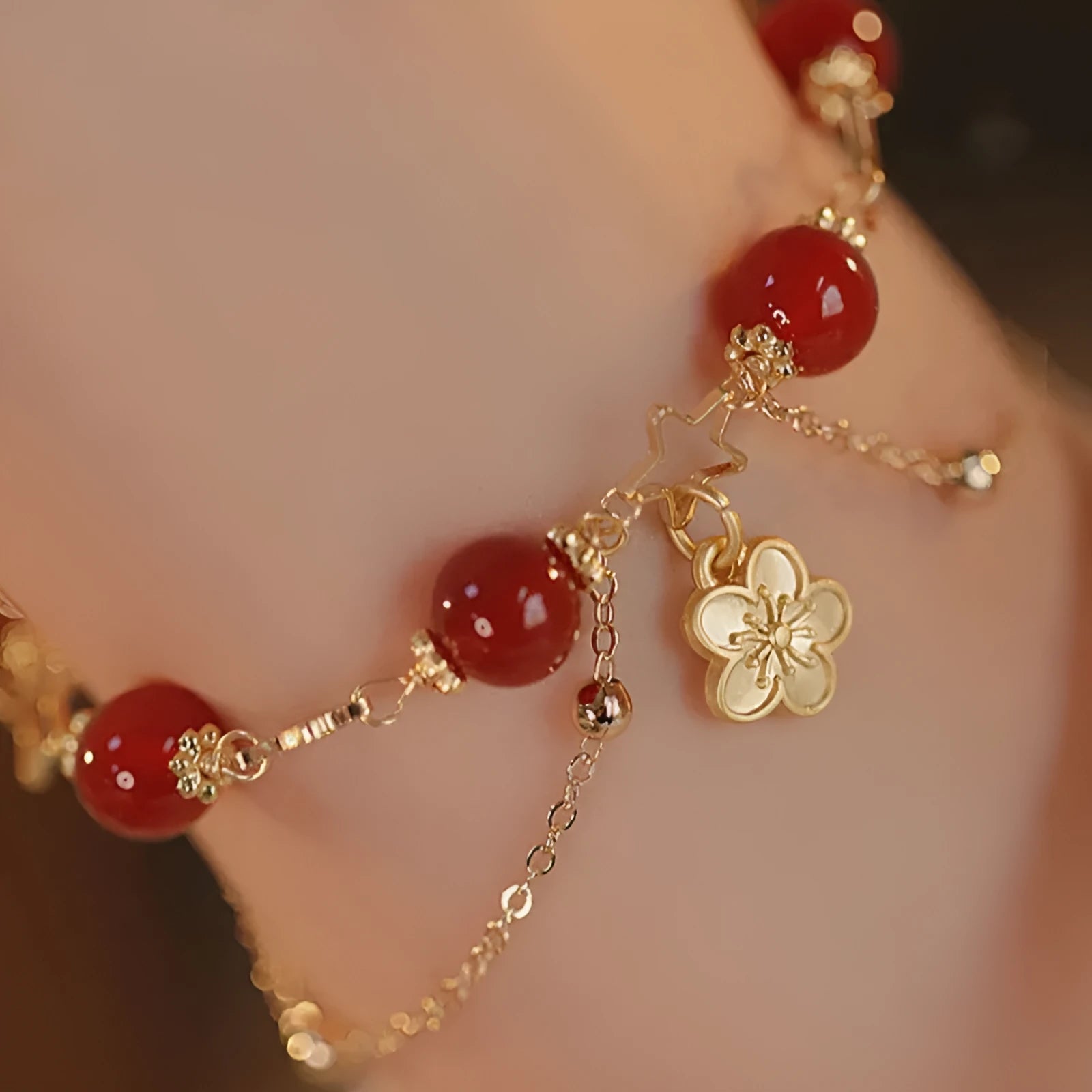 Close-up of a red agate double layer women's bracelet with floral and peach blossom motifs.