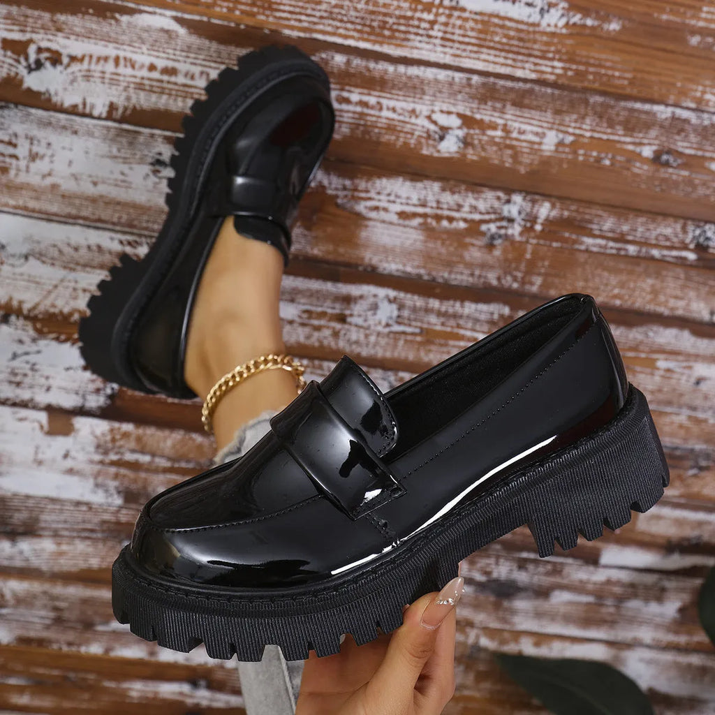 Women's plus size black slip-on loafers with a chunky platform heel and mid-top design.
