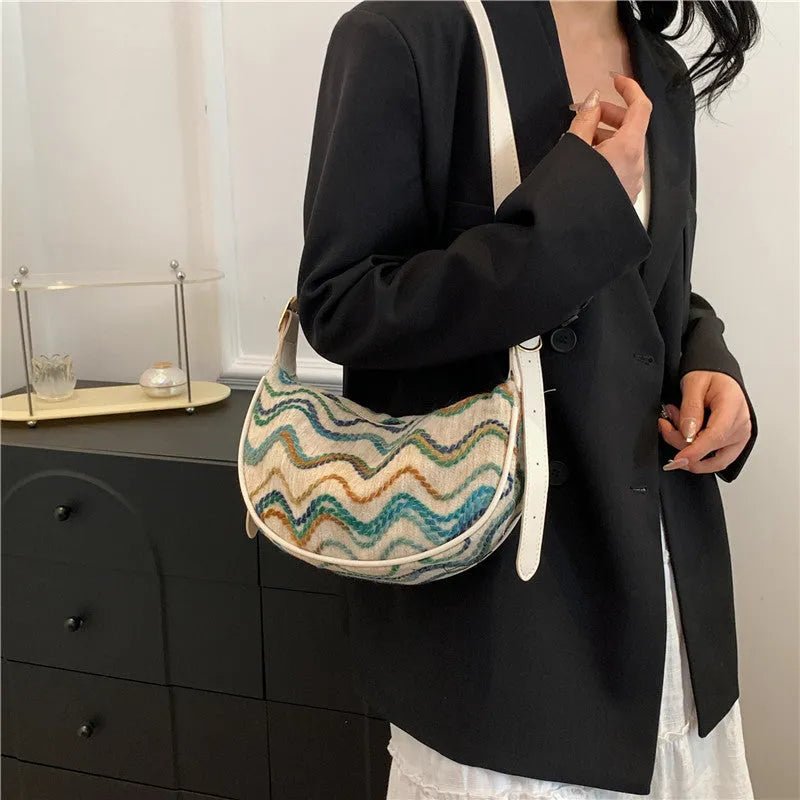 Women's woven straw crossbody bag showing textured surface with phone and file compartments inside