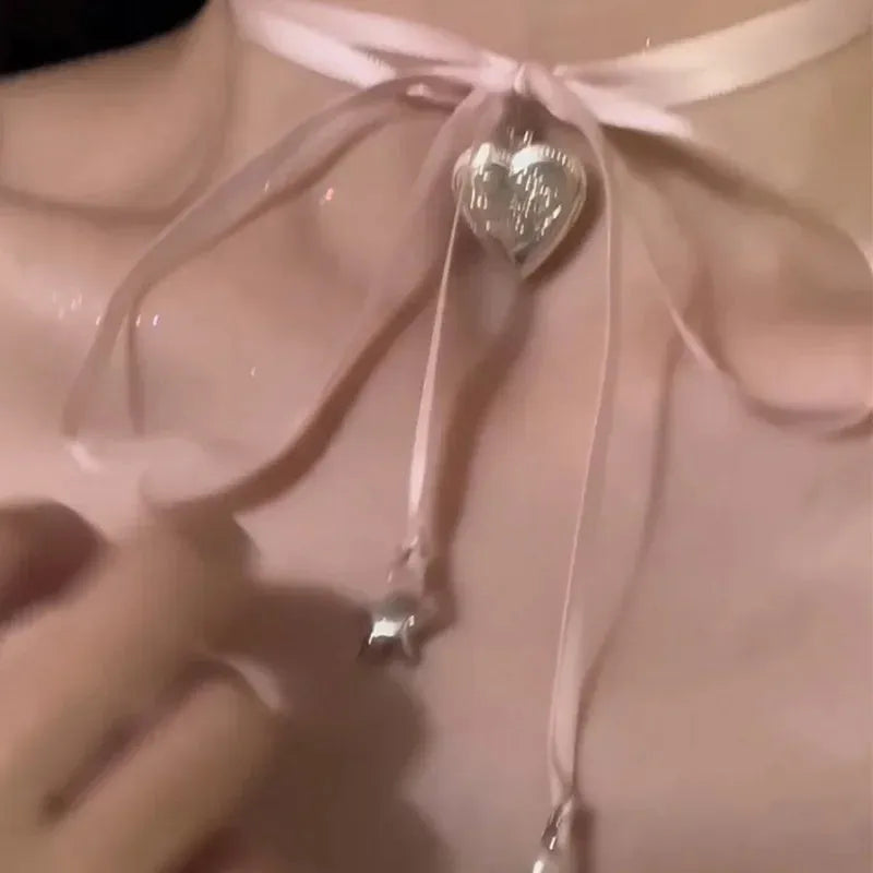Women's alloy fashion necklace with a detailed ribbon and love pendant design on a clavicle chain, shown in one of 33 colour options.