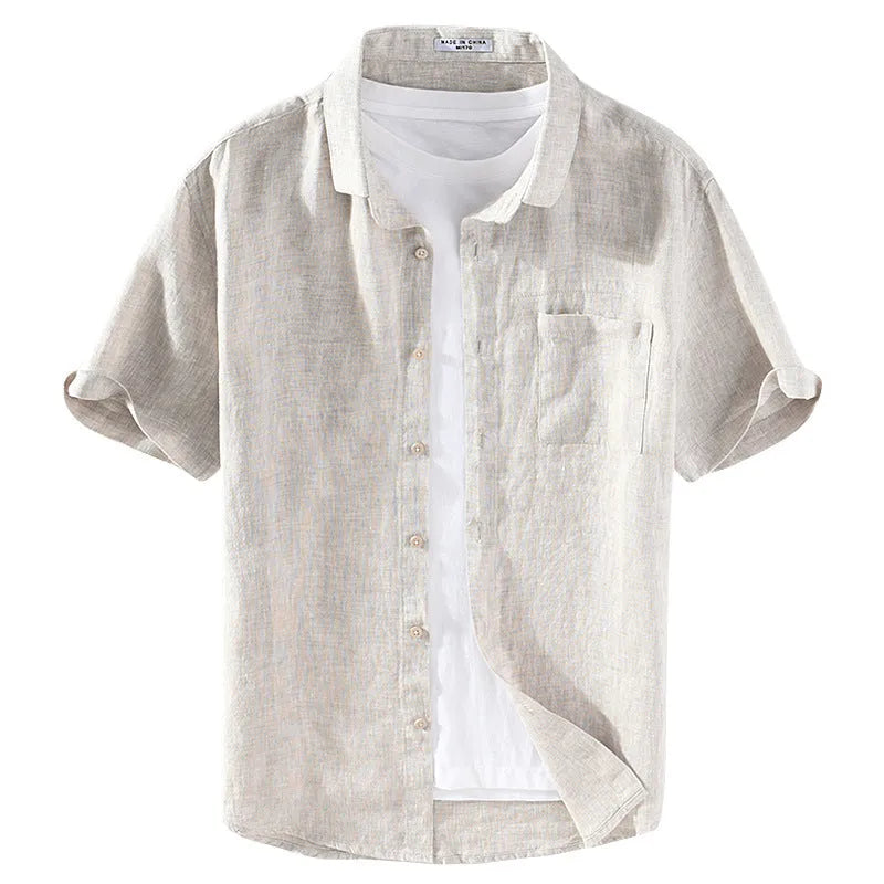 Man wearing a raw jute coloured short sleeve linen shirt with a square collar.