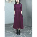 A purplish red plus size long sleeve dress with an ankle-length skirt on a mannequin.