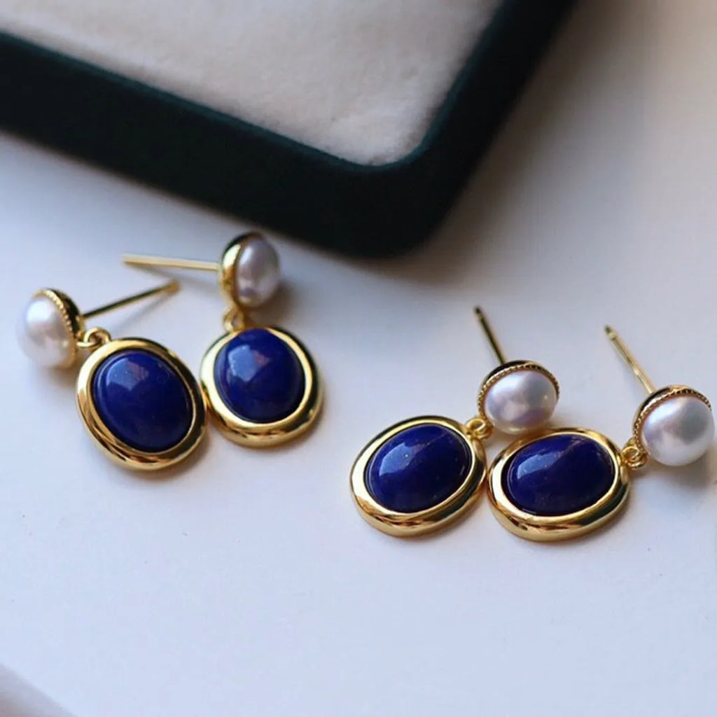A pair of simple sterling silver drop earrings with blue lapis lazuli pearls and an auspicious pattern.