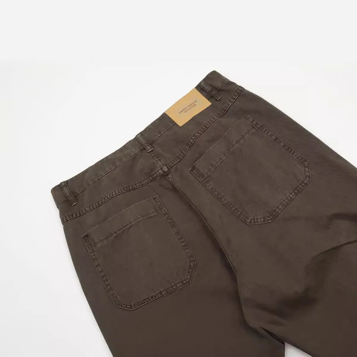 Men's brown loose straight leg jeans with high waist design and zip fly closure