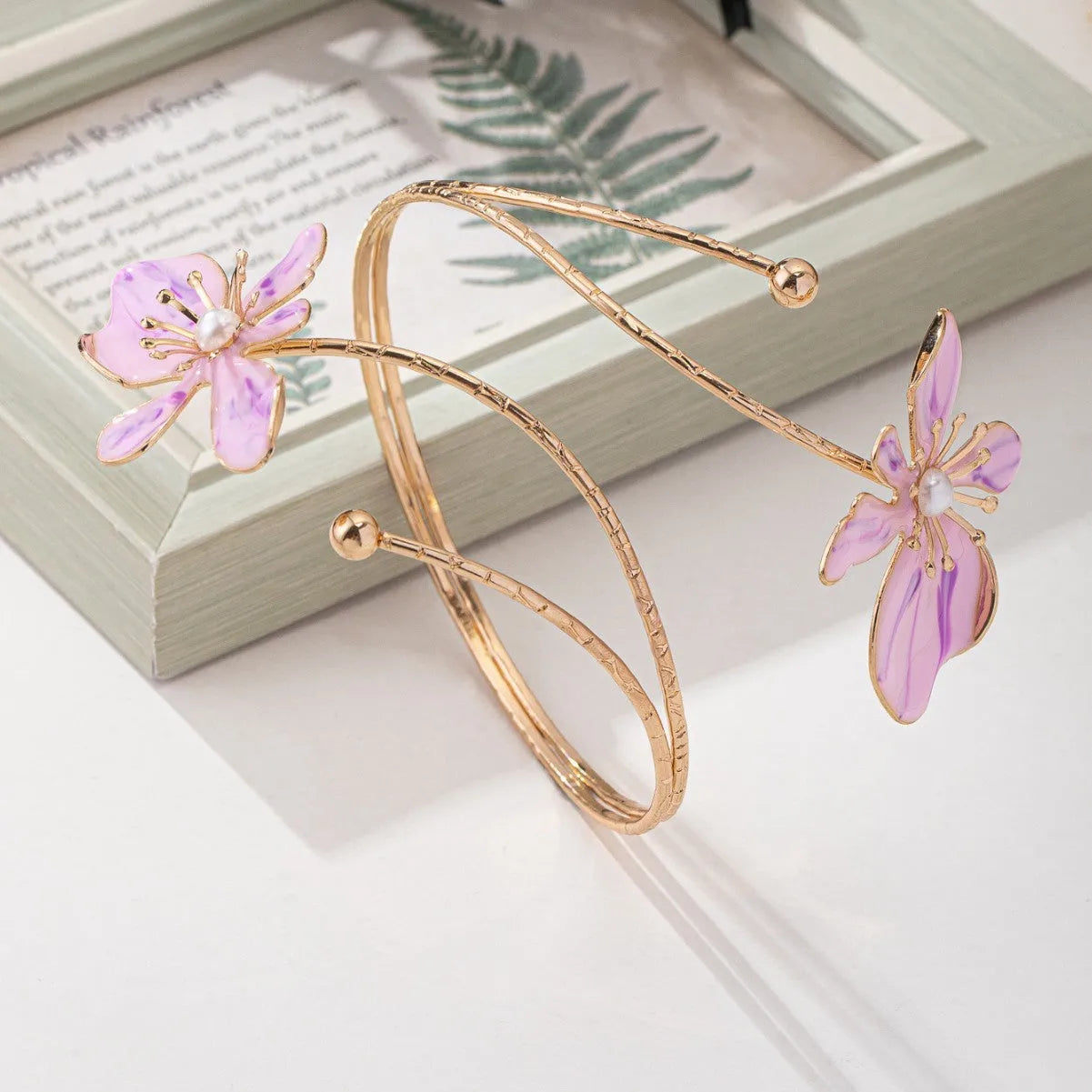 Close-up of a pink hollow patterned alloy armband for women's fashion.