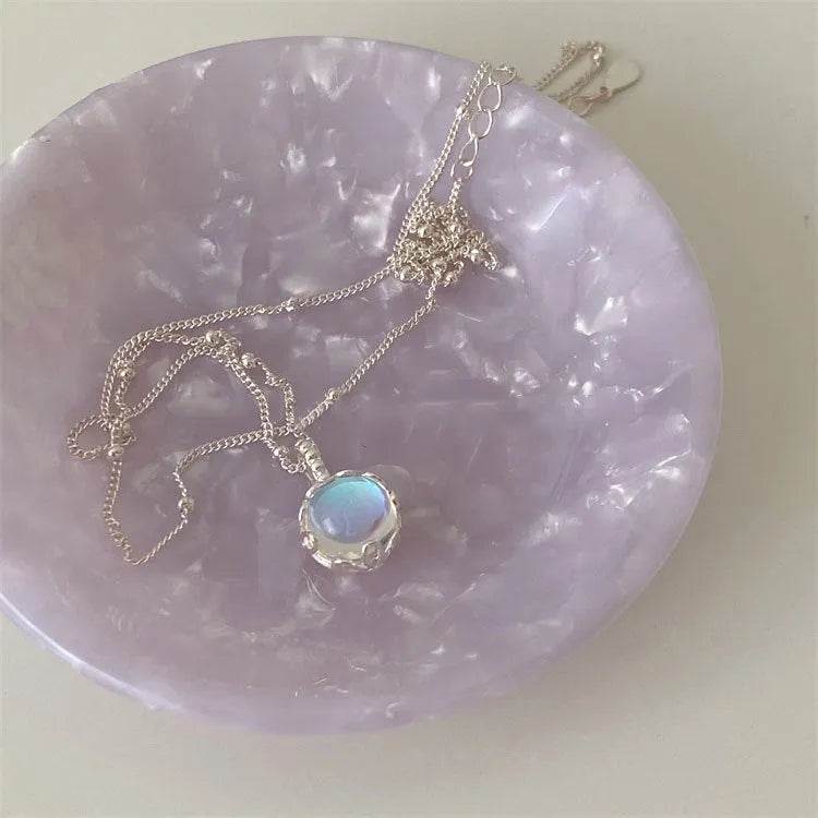 Silver women's necklace with round ornamental stone geometric pendant on a curb chain.