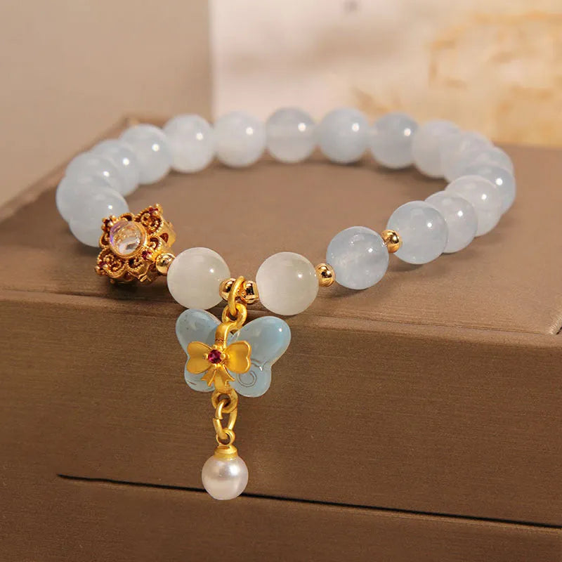 Aquamarine crystal butterfly pendant bracelet for women with rhinestone accents on a white background.