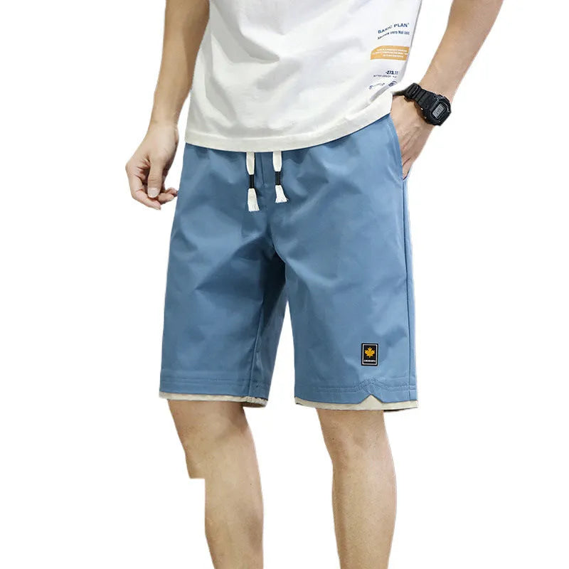 Man's loose fit casual shorts in green, shown flat, highlighting the straight cut and elastic waistband.