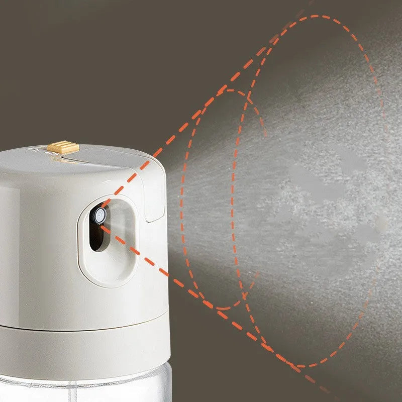 Glass oil sprayer bottle with grey cap, shown in spray and pour modes next to cooking ingredients.