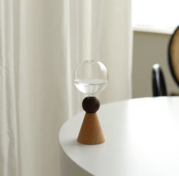 Geometric clear glass bubble vase on wooden base with conical or arc bottom designs