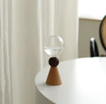 Geometric clear glass bubble vase on wooden base with conical or arc bottom designs
