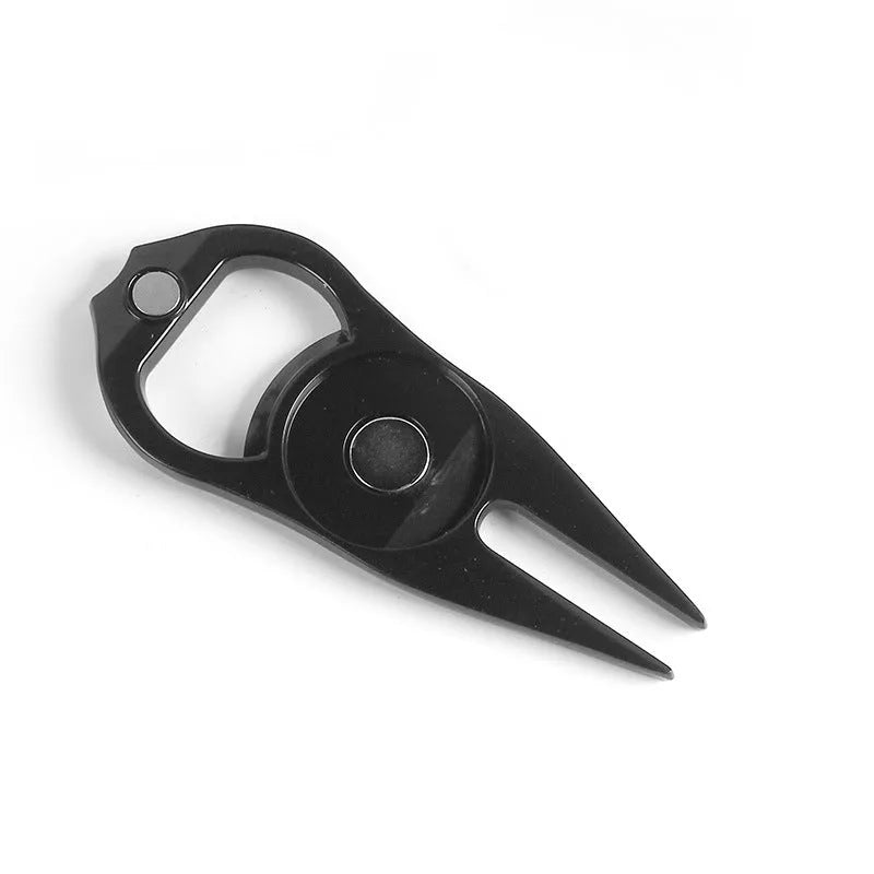 Black zinc alloy golf ball yoke bottle opener tool on a putting green.
