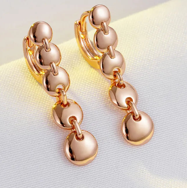 Gold-coloured retro woven round copper earrings showing textured circle design.