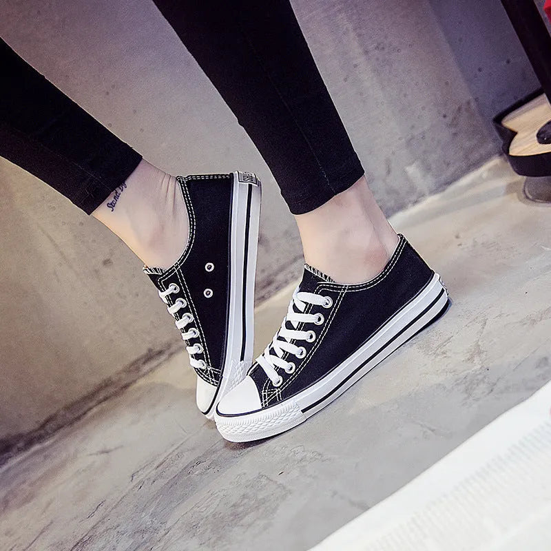 Women's solid colour canvas slip-on sneaker in black on a white background.