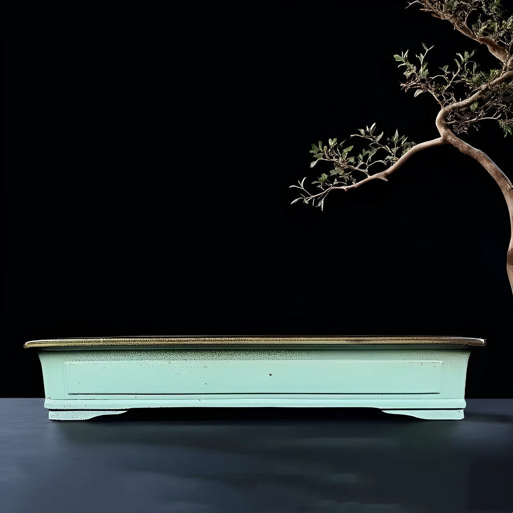 Green handmade ceramic bonsai pot with retro crackled glaze finish on wooden surface
