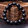 Natural frosted black agate bracelet engraved with a Sanskrit mantra, showing stone-coloured glaze.