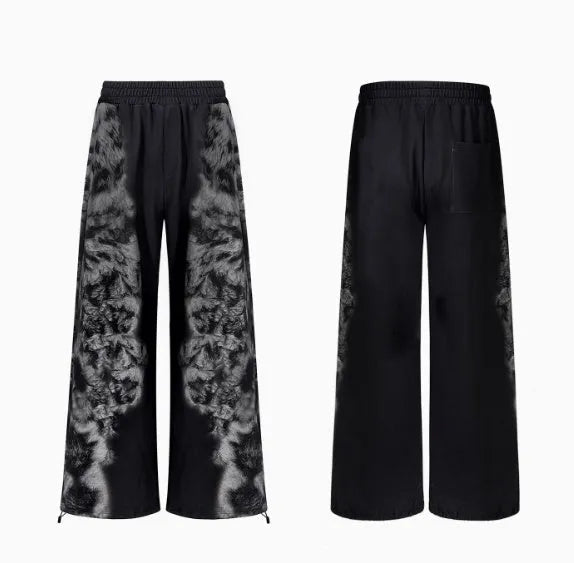 Loose fitting printed casual trousers with a hoodie on a neutral background