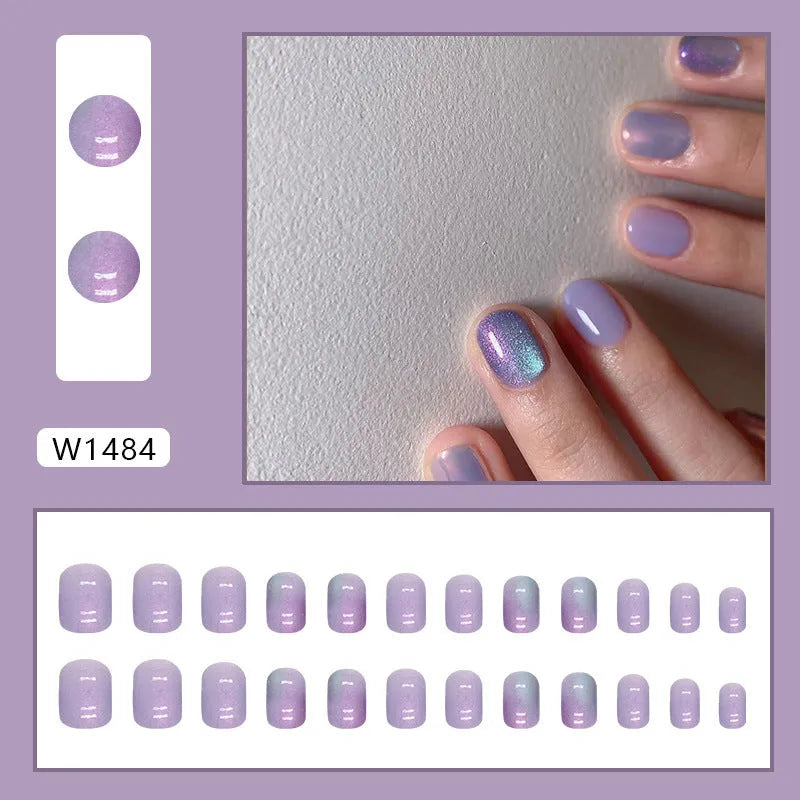 Short false nails with bright Aurora starry sky pattern and included glue tube.