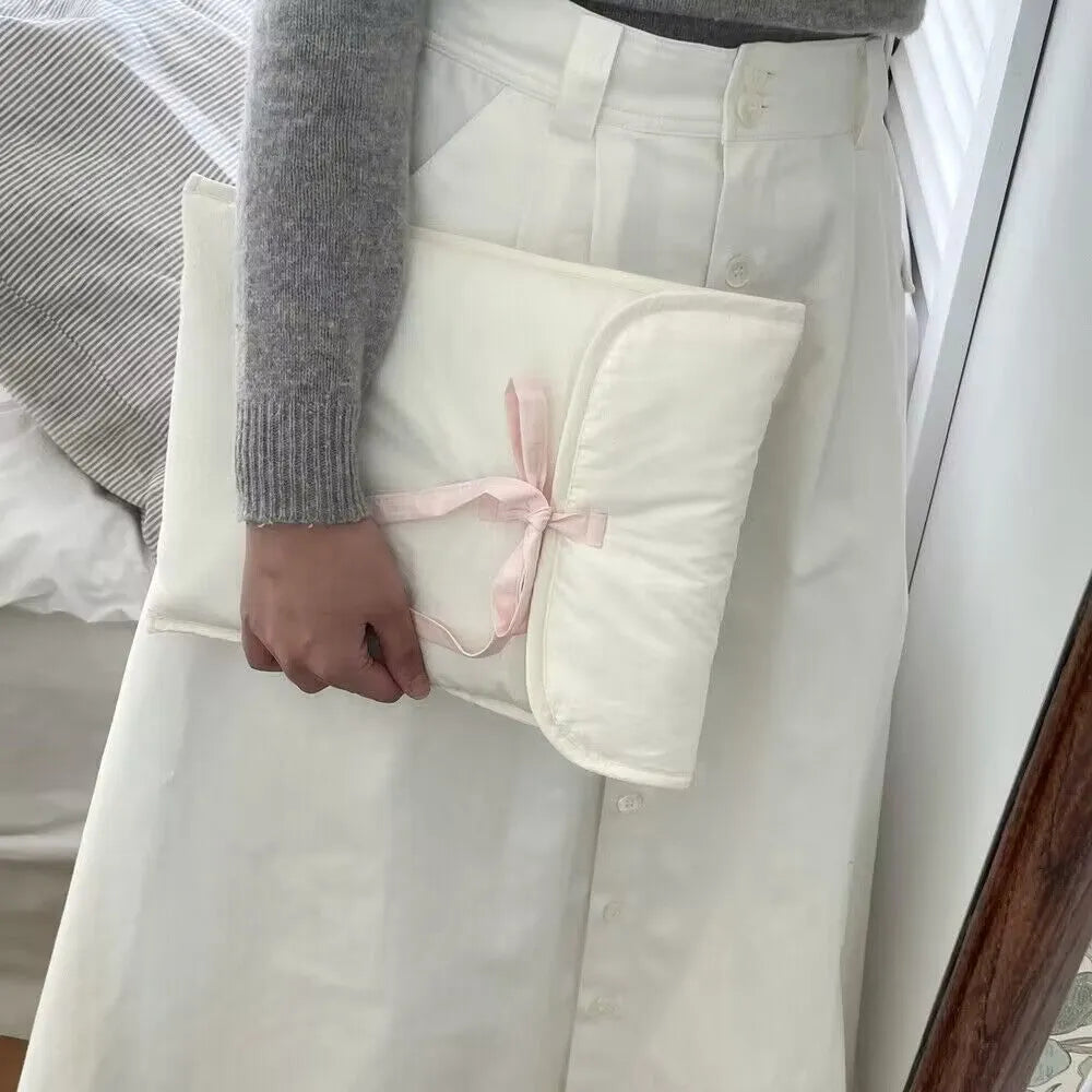 Black and white quilted laptop bag with a large ballet-style bow on the front.