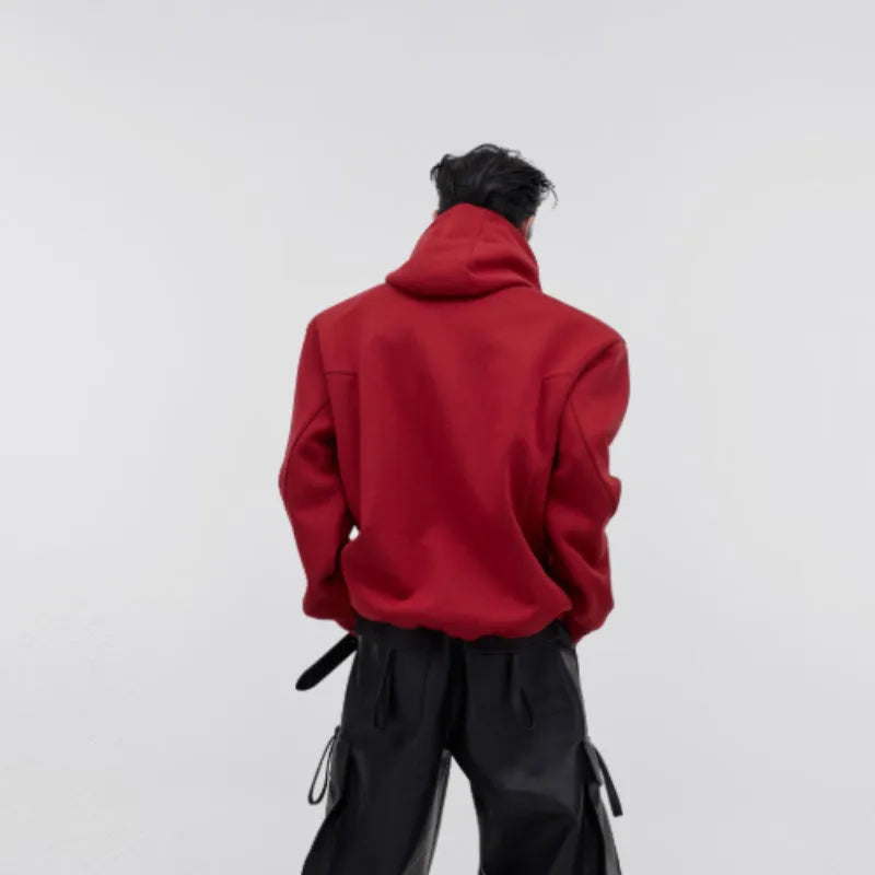 Men's loose red hooded sweater with heavy shoulder pads and a metallic 3D printed design on the front.