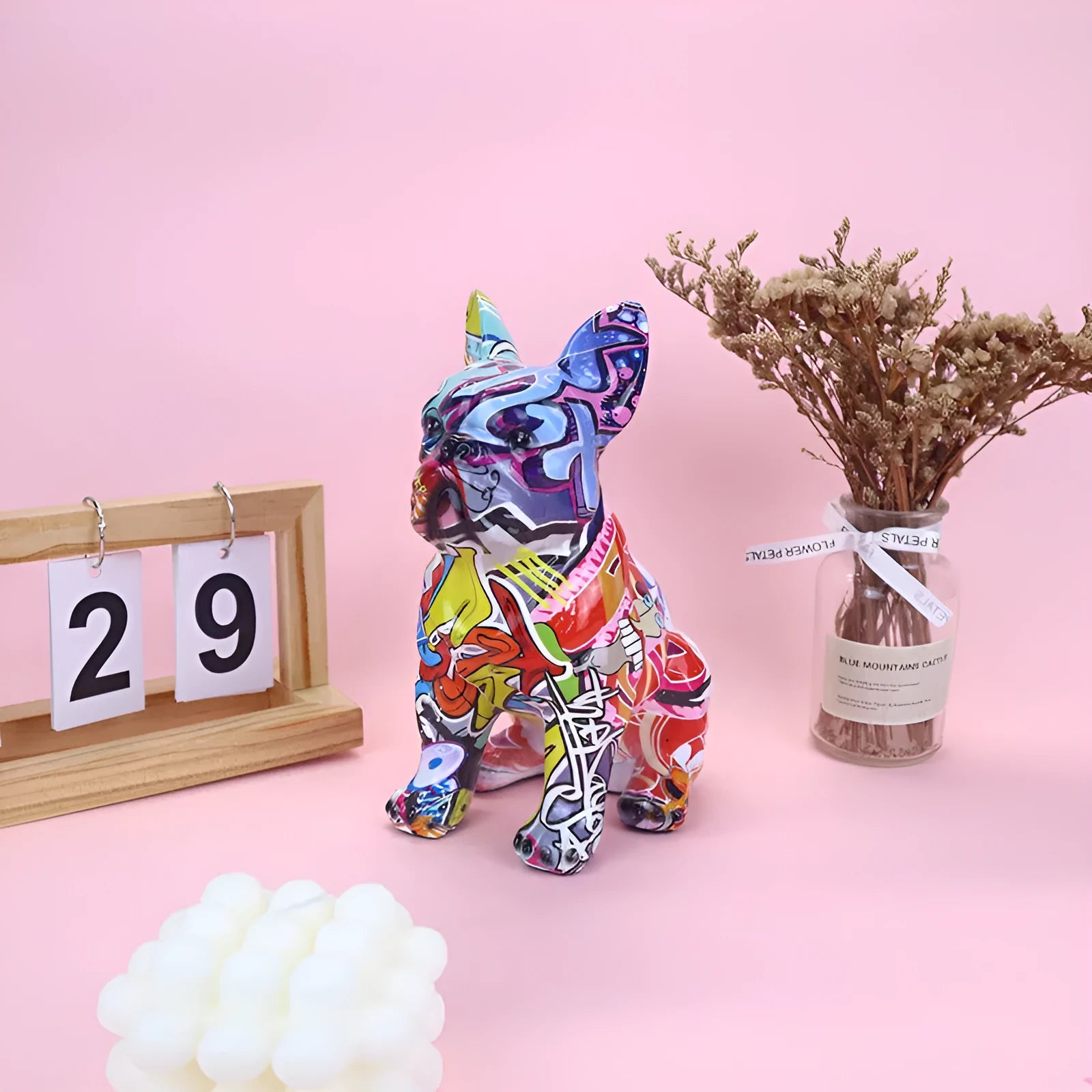 Graffiti-coloured French bulldog resin statue on a shelf, showing modern simple style.