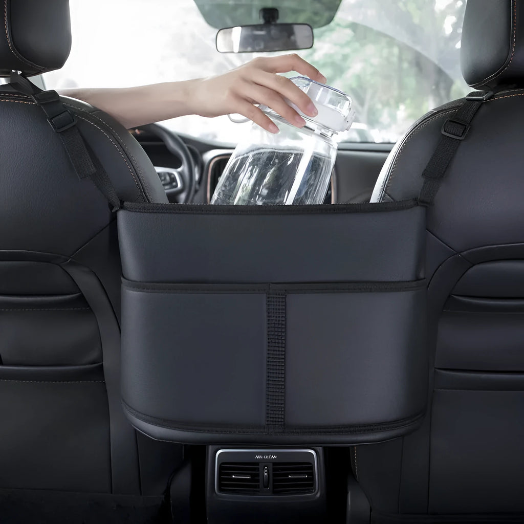 Black leather car seat storage bag with carbon fibre pattern, shown fitted in a car seat net pocket.