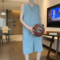 Man wearing a grey sleeveless polyester vest and matching shorts basketball sports set.