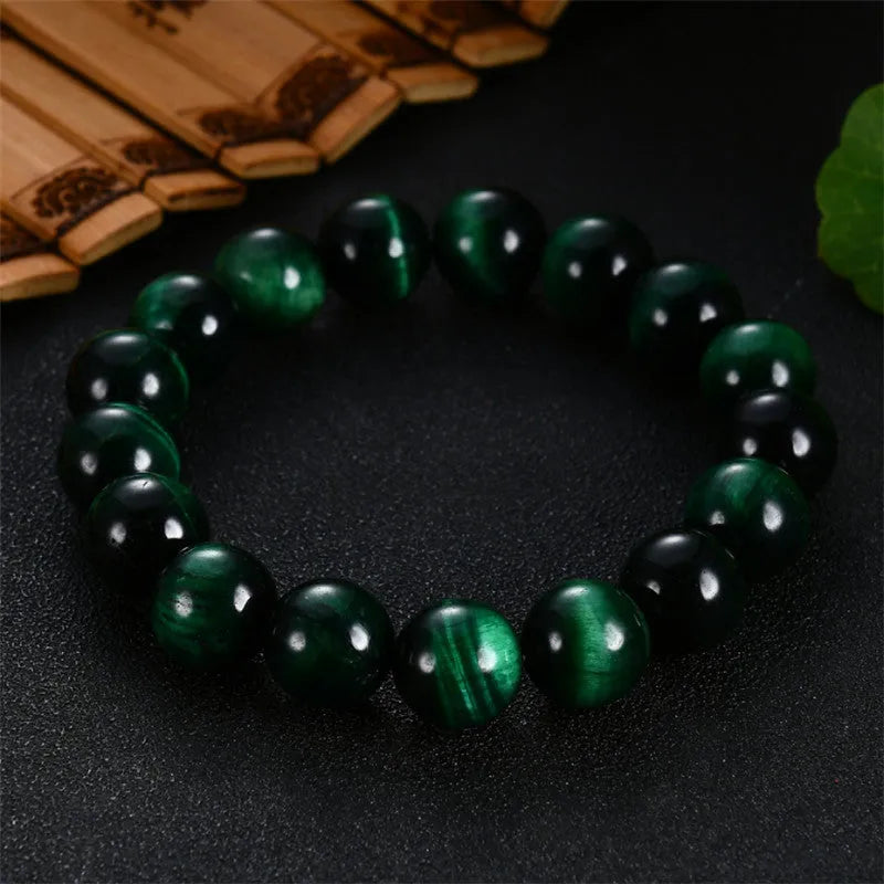 Natural green tiger eye stone bracelet with polished spherical beads in geometric design on wrist.