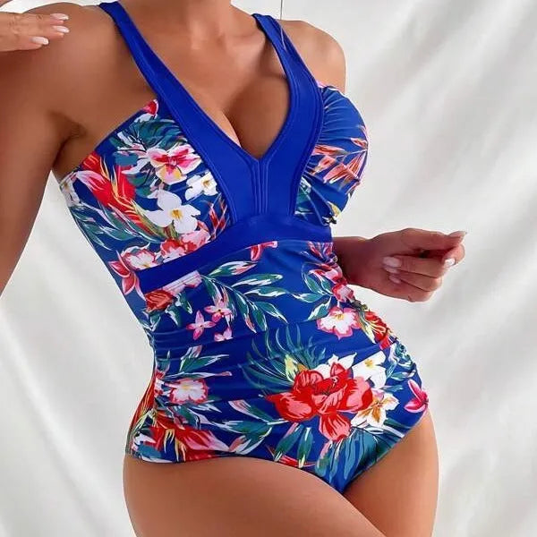 Women's floral one-piece swimsuit with backless design on a mannequin, showing high elasticity.