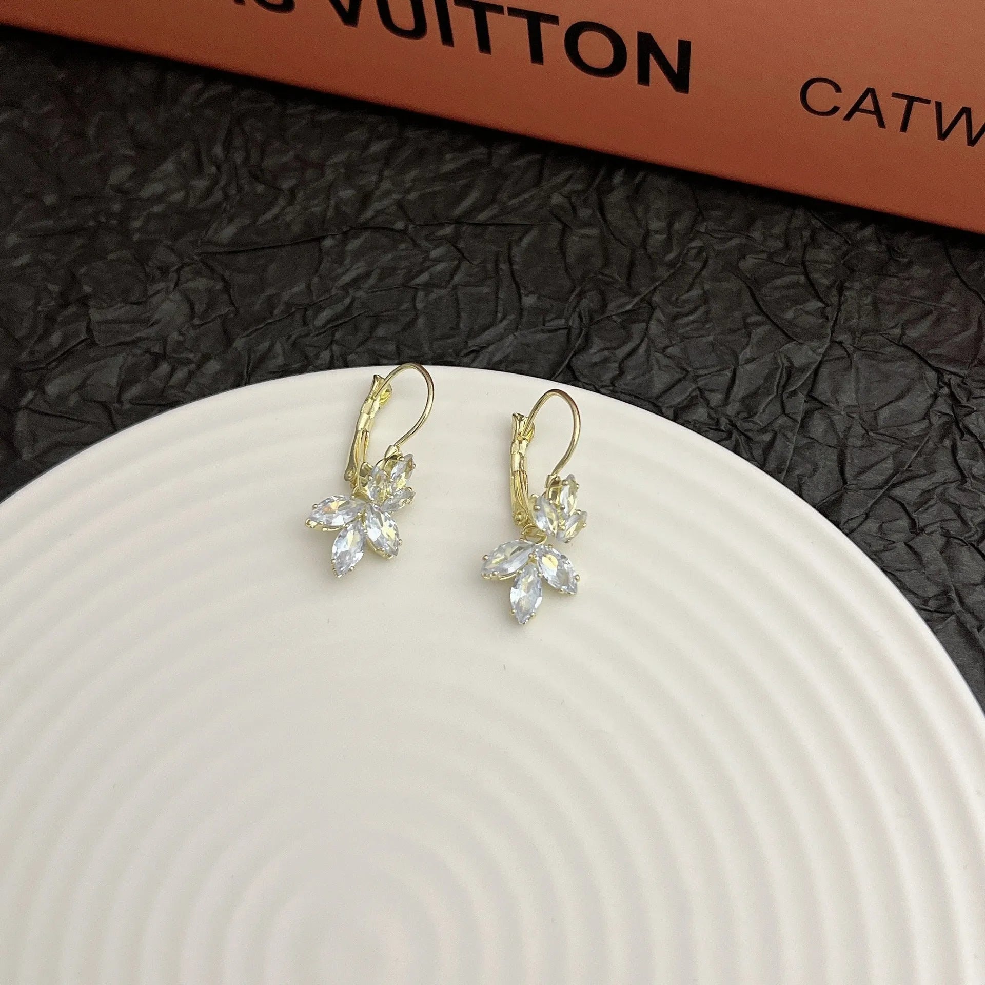 Platinum colour leaf-shaped earrings with zircon inlay creating shiny reflective surfaces