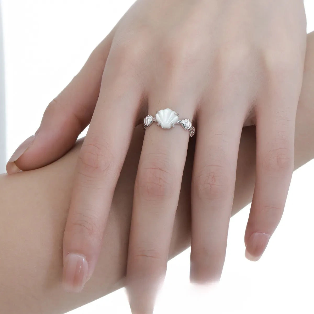 Silver adjustable ring with a white shell and tiger eye stone design in electroplated finish