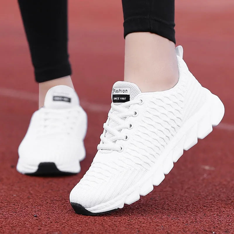 Women's running shoes in black, pink, or white with a fly weave upper and durable outsole.