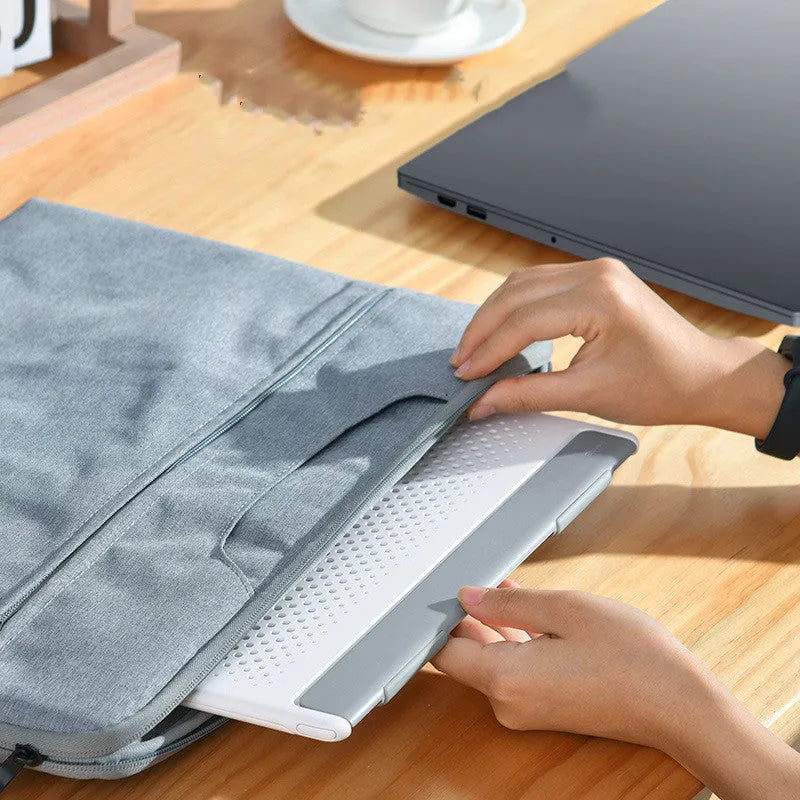 Black alloy portable notebook stand for laptops under 16 inches on a desk.