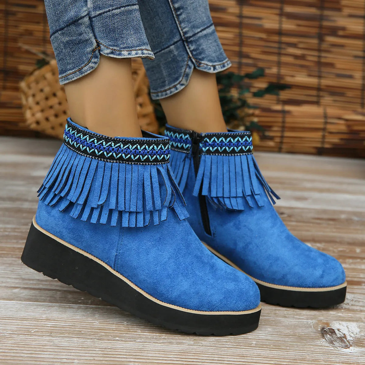 Women's black suede wedge ankle boots with a side zip and tassel detail on a thick rubber sole.