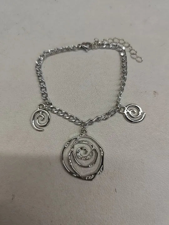 Geometric spiral donut jewellery set showing necklace, bracelet, and earrings in gold electroplated finish