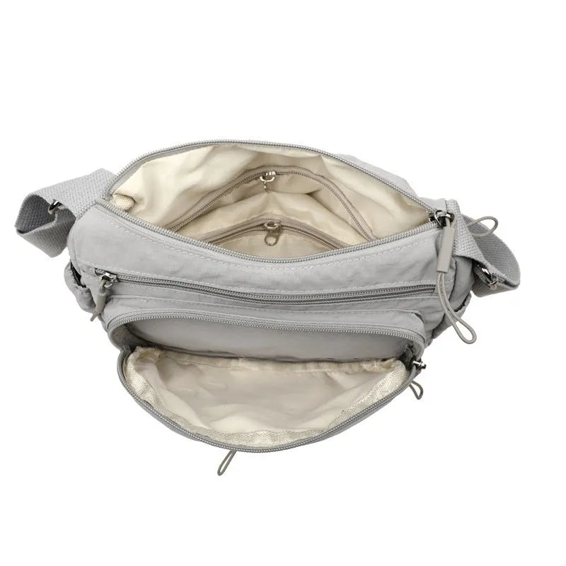 Water-repellent nylon crossbody cloth bag in black, grey or red with internal zipper compartments
