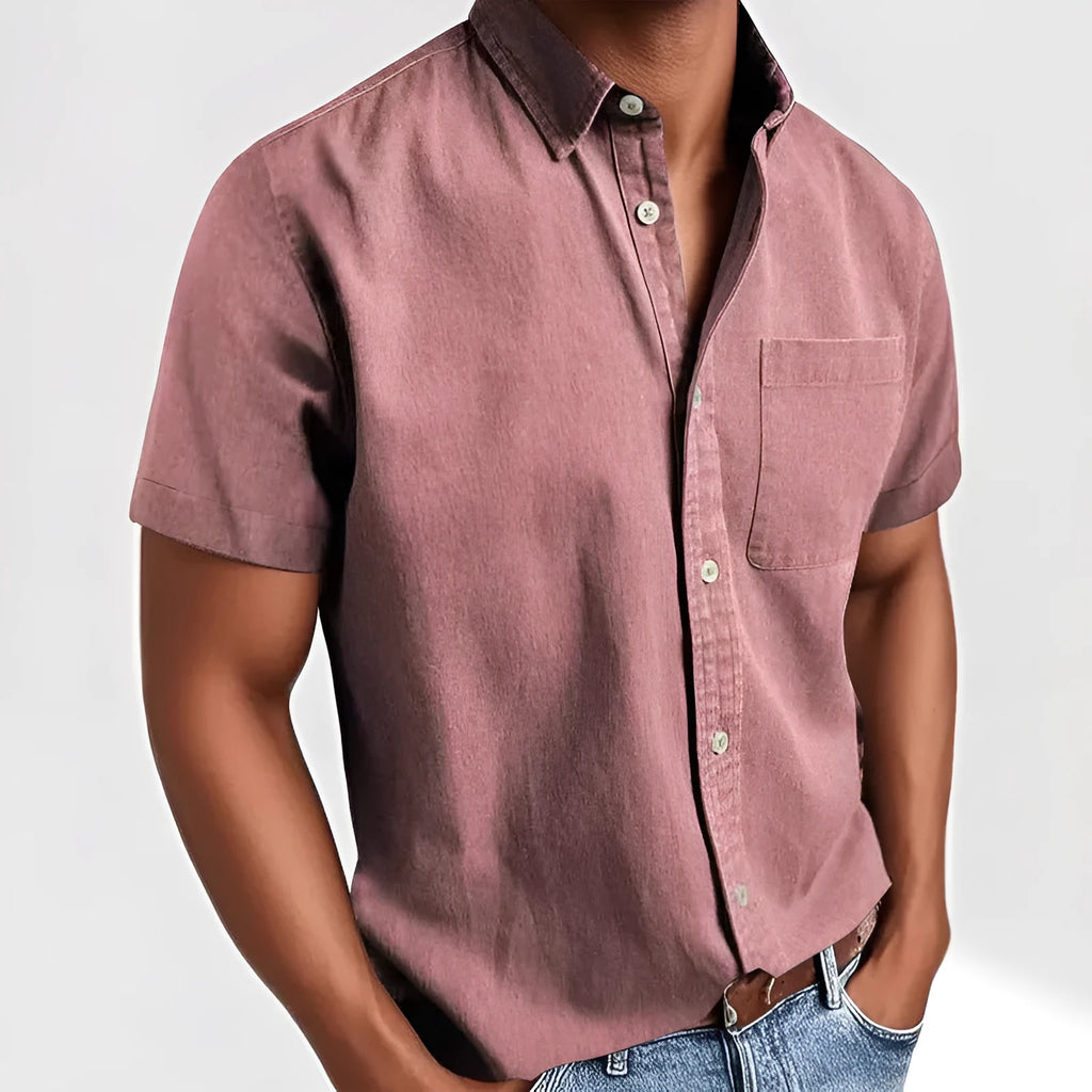 Man wearing a solid colour short-sleeved shirt with a polo collar and a single chest pocket.