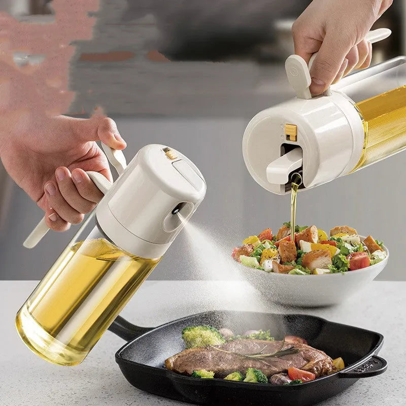 Glass oil sprayer bottle with grey cap, shown in spray and pour modes next to cooking ingredients.