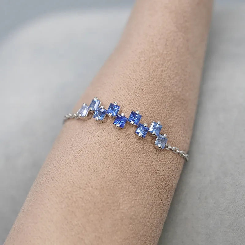 Square blue stone ring with adjustable copper band and floral leaf detailing in blue