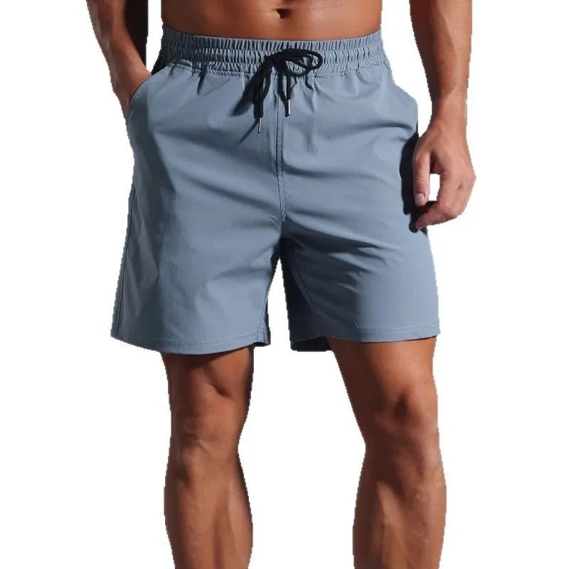 Man wearing loose-fitting khaki coloured casual polyester shorts with a straight leg and mid-waist.