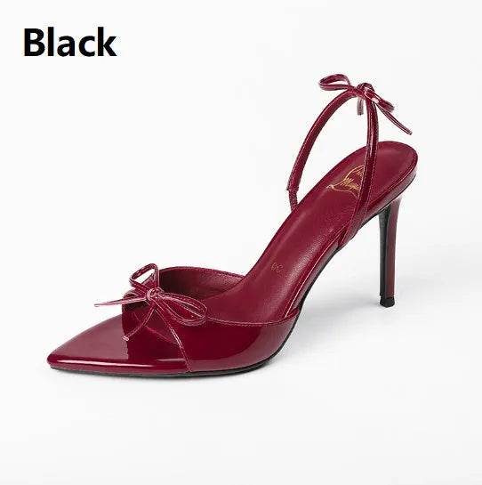Women's black pointed stiletto high heels with open toe and ankle strap buckle on a white background.