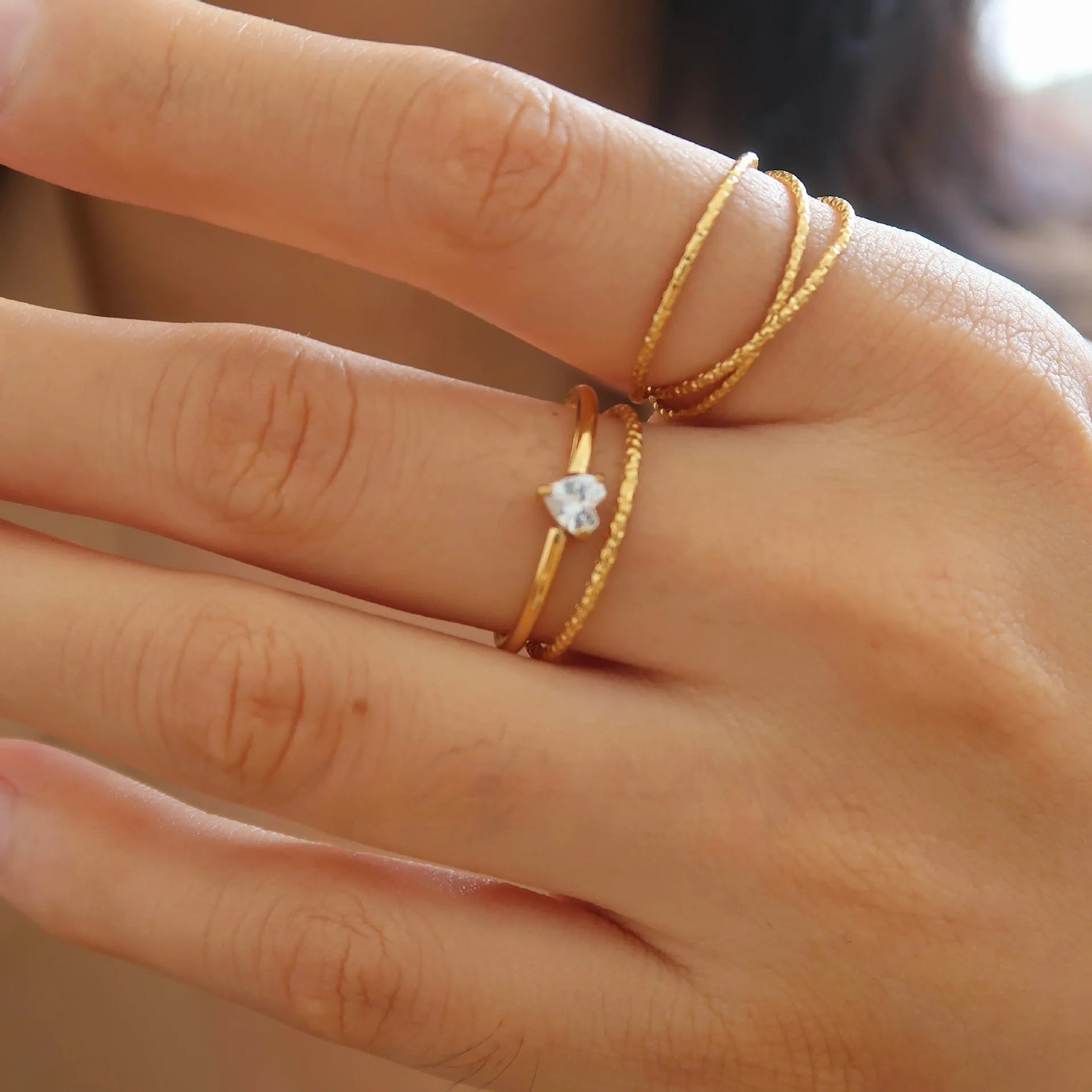 Golden love heart stainless steel ring for women on a simple band, shown in sizes no.5 to no.8