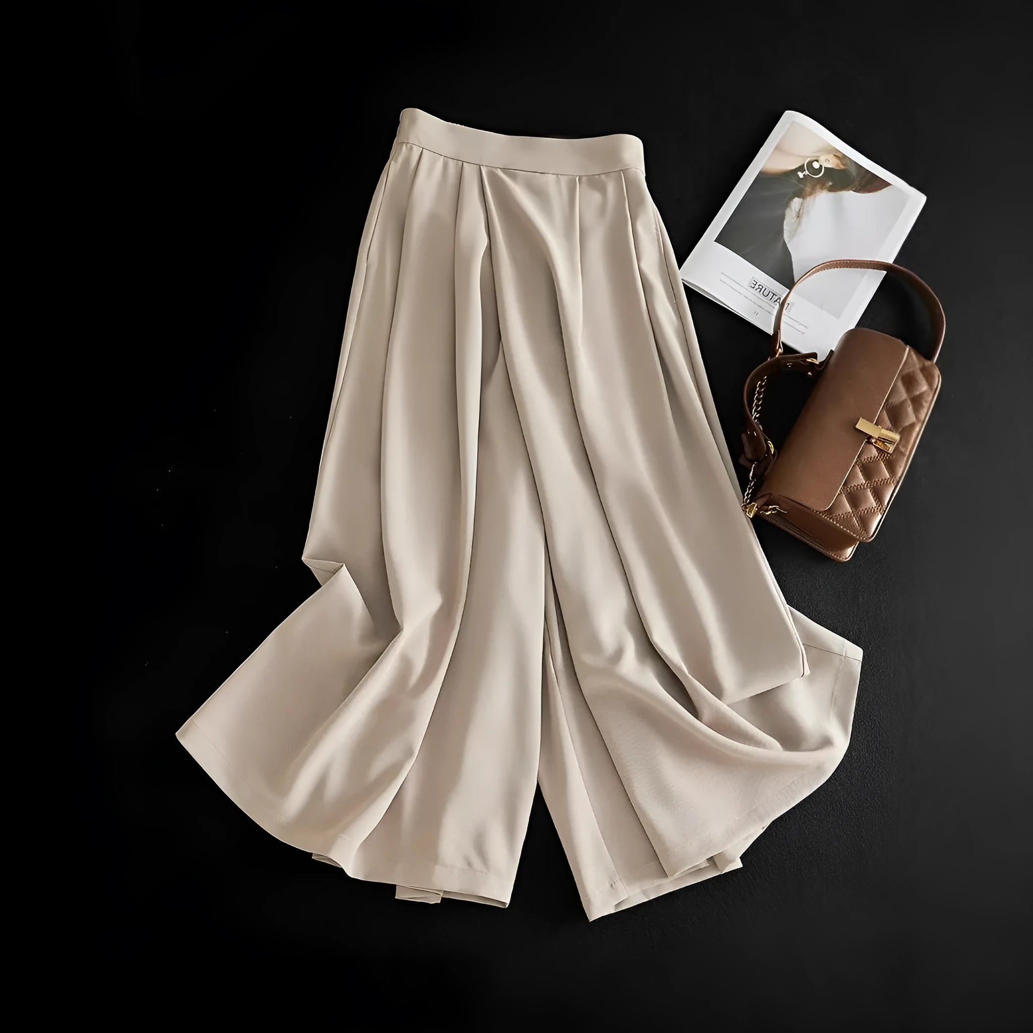 Wide-leg women's trousers in milk apricot with stacked hem design and pockets, flat lay view