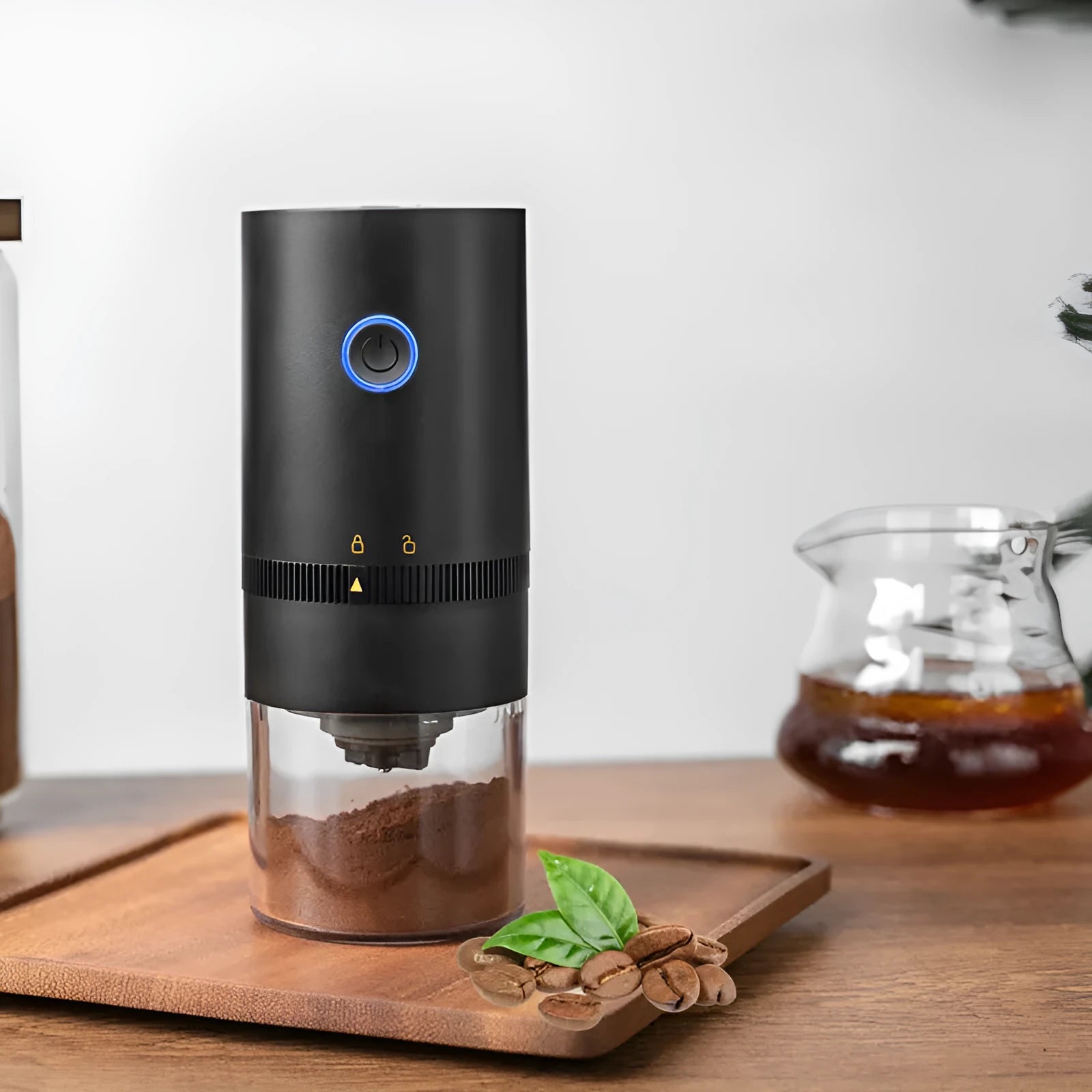 Black portable electric coffee grinder with transparent chamber showing coffee beans, USB-C charging port visible