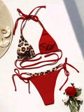 Red leopard print women's bikini with halter neck and lace-up front detail.