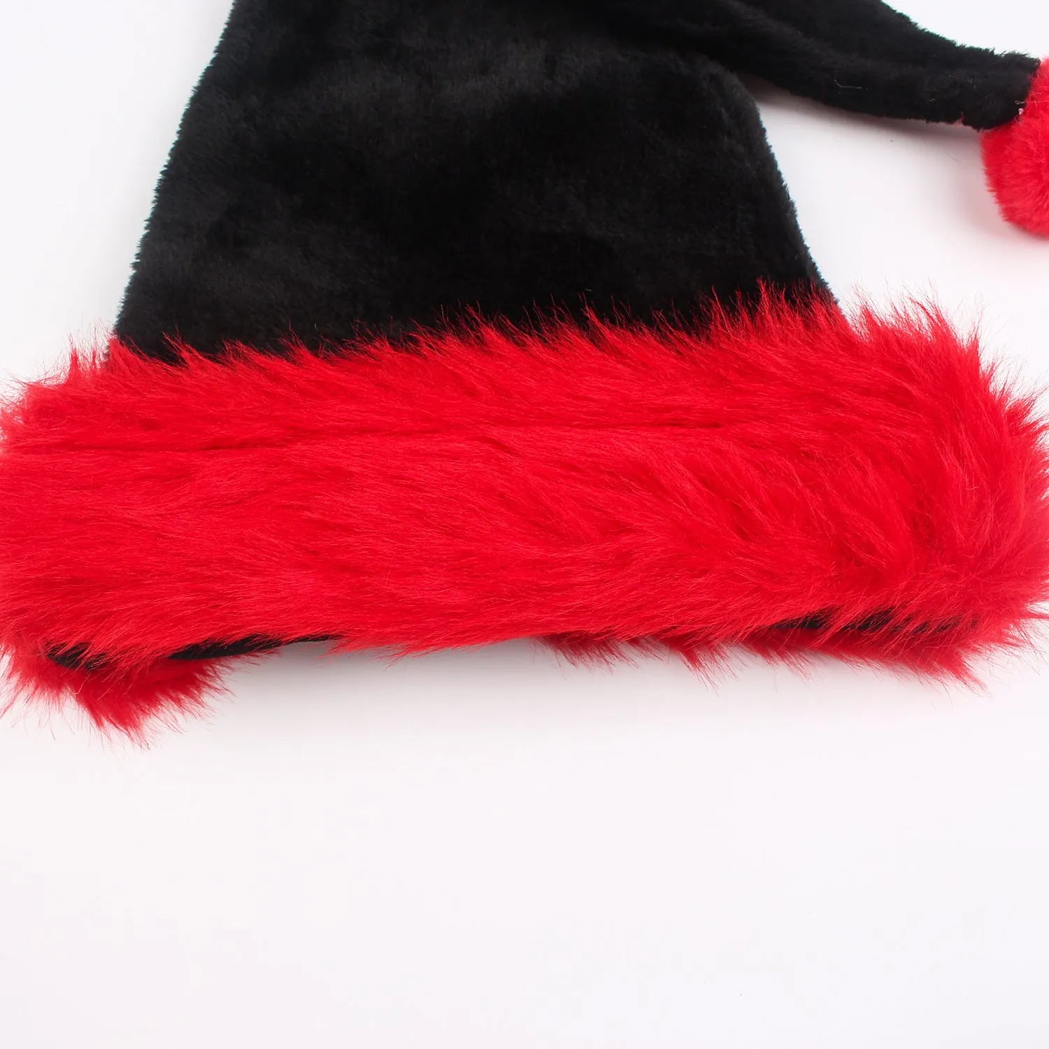 Large red and black plush Christmas hat with classic European design, shown next to a white and black version.