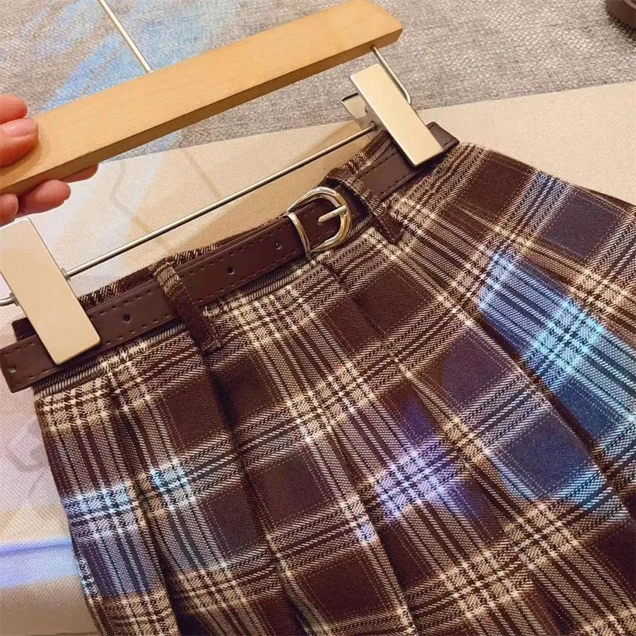 Girls' plaid pleated A-line skirt in a cotton blend fabric, shown on a hanger.